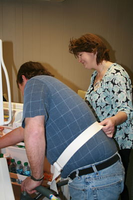 A Occupational Therapist is assisting a patient to the refrigerator